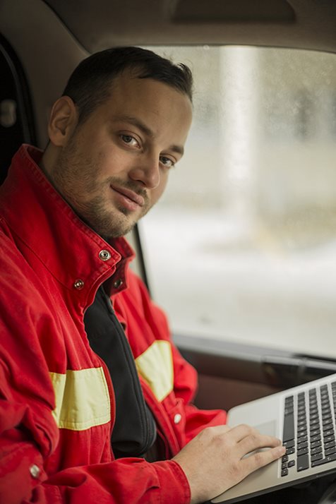 Un pompier dans un véhicule avec un ordinateur portable