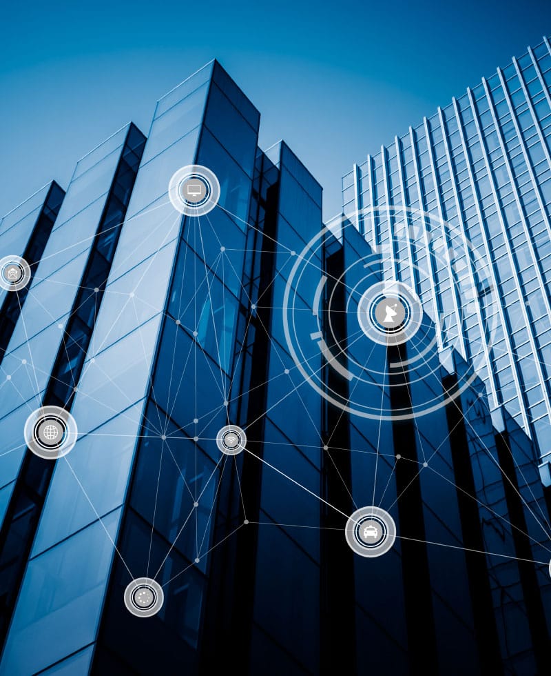 Bâtiments modernes en verre avec des icônes de réseaux numériques superposées, symbolisant la technologie des bâtiments intelligents.