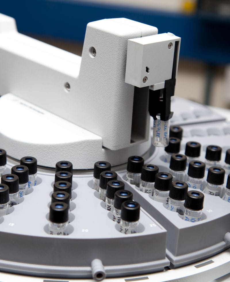 Gros plan d'un analyseur de chromatographie en phase gazeuse avec des flacons d'échantillons.